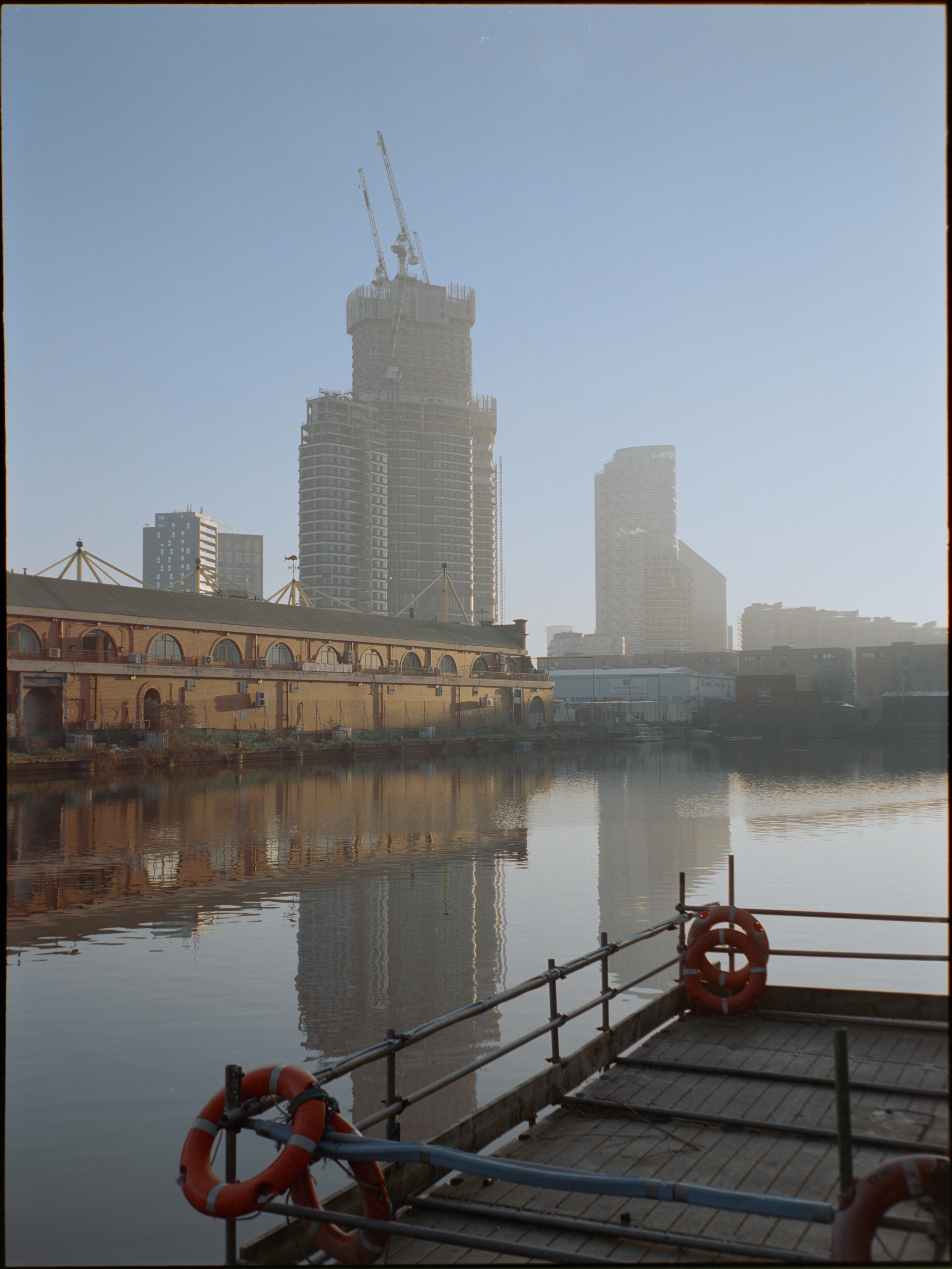 Canary Wharf buildings across water in warm golden light — Kodak Portra 160 on Fujifilm GA645S