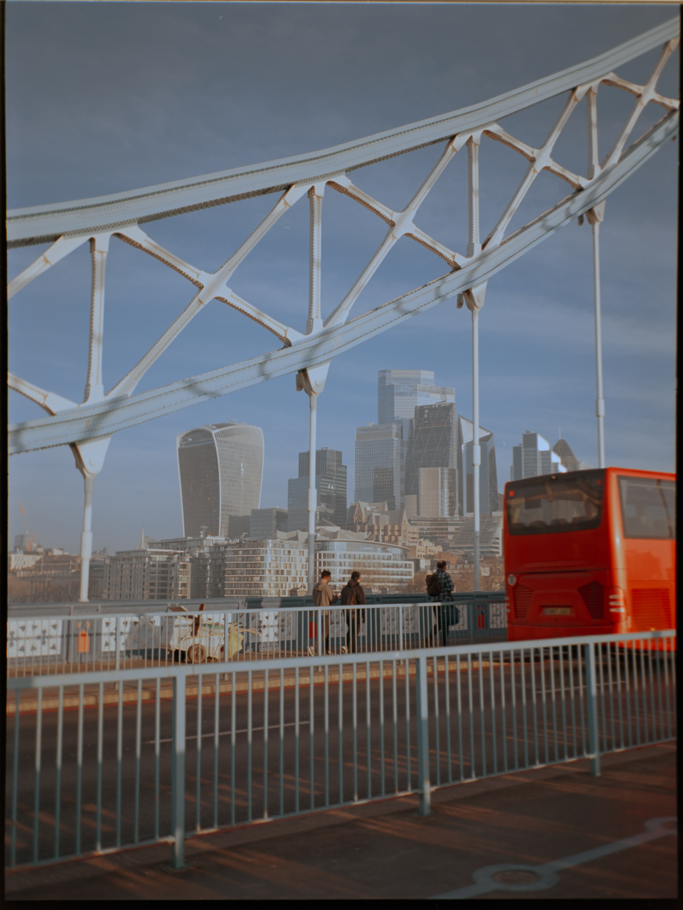 Tower Bridge ironwork framing the City of London skyline with a red bus — Fujifilm GA645S Ektar 100