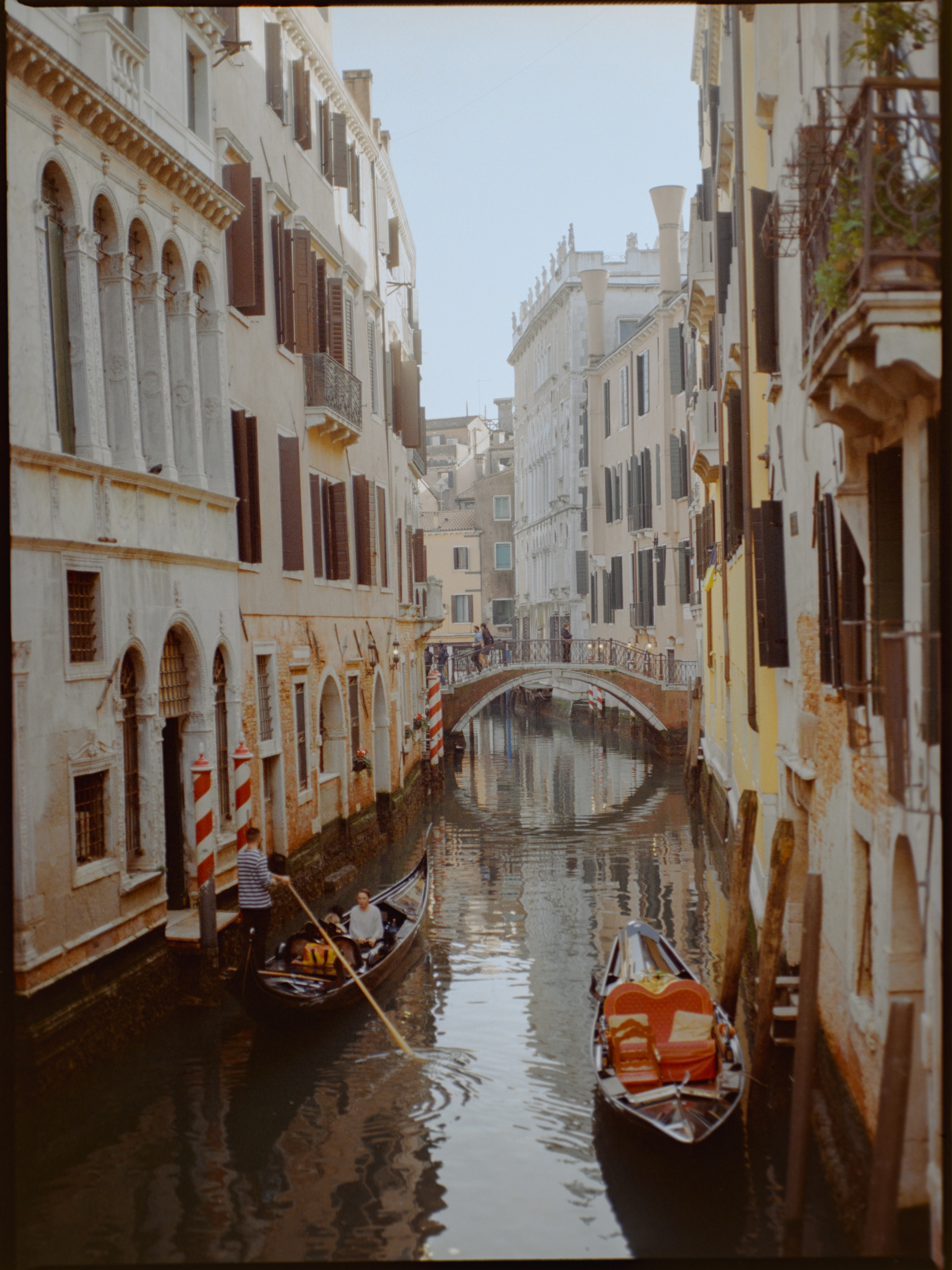 Gondola passing under a small bridge on a quiet canal — Venice on medium format film