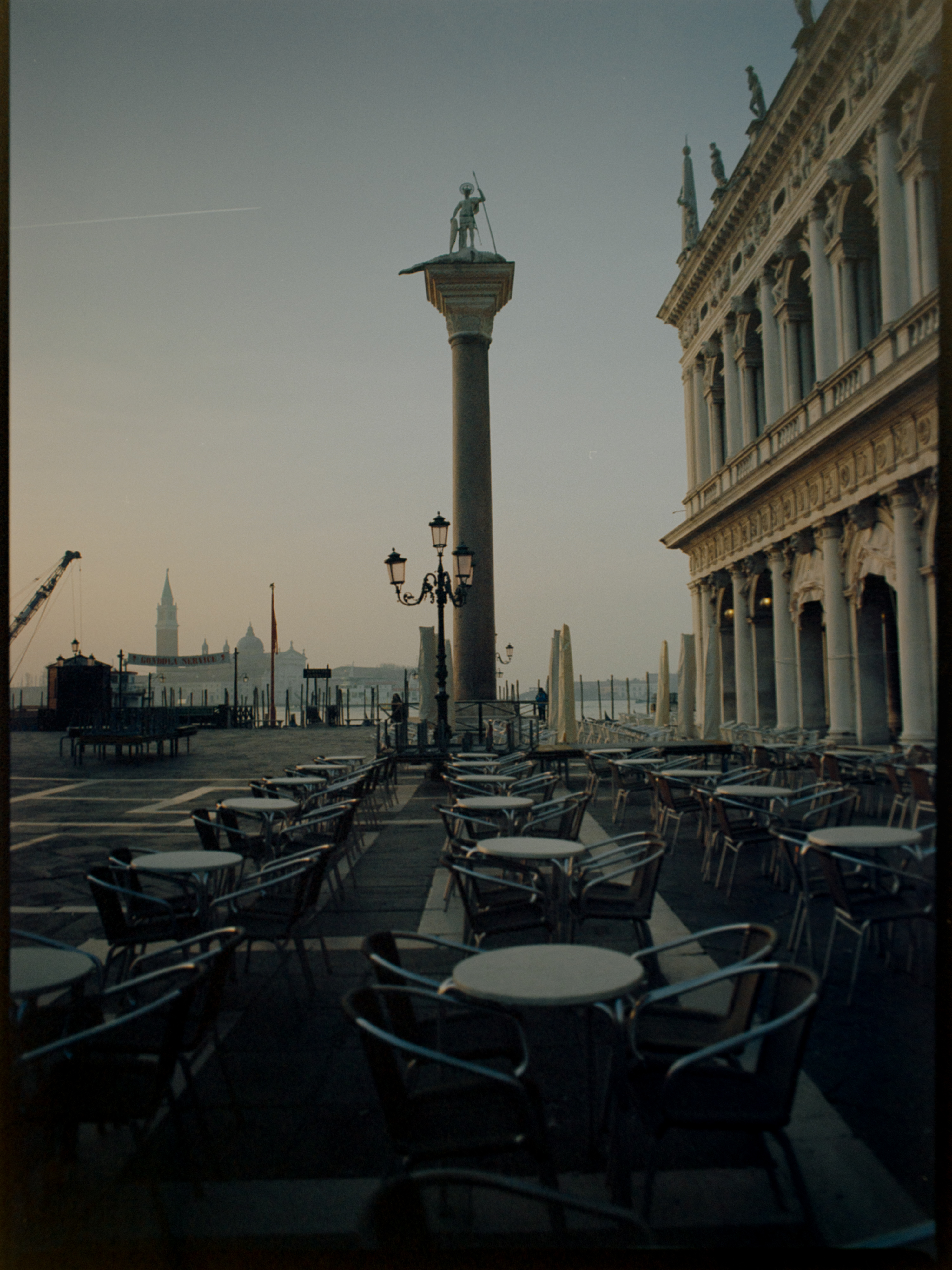 Empty cafe tables facing the waterfront at dawn with San Giorgio Maggiore behind — Venice on Kodak Ektar 100