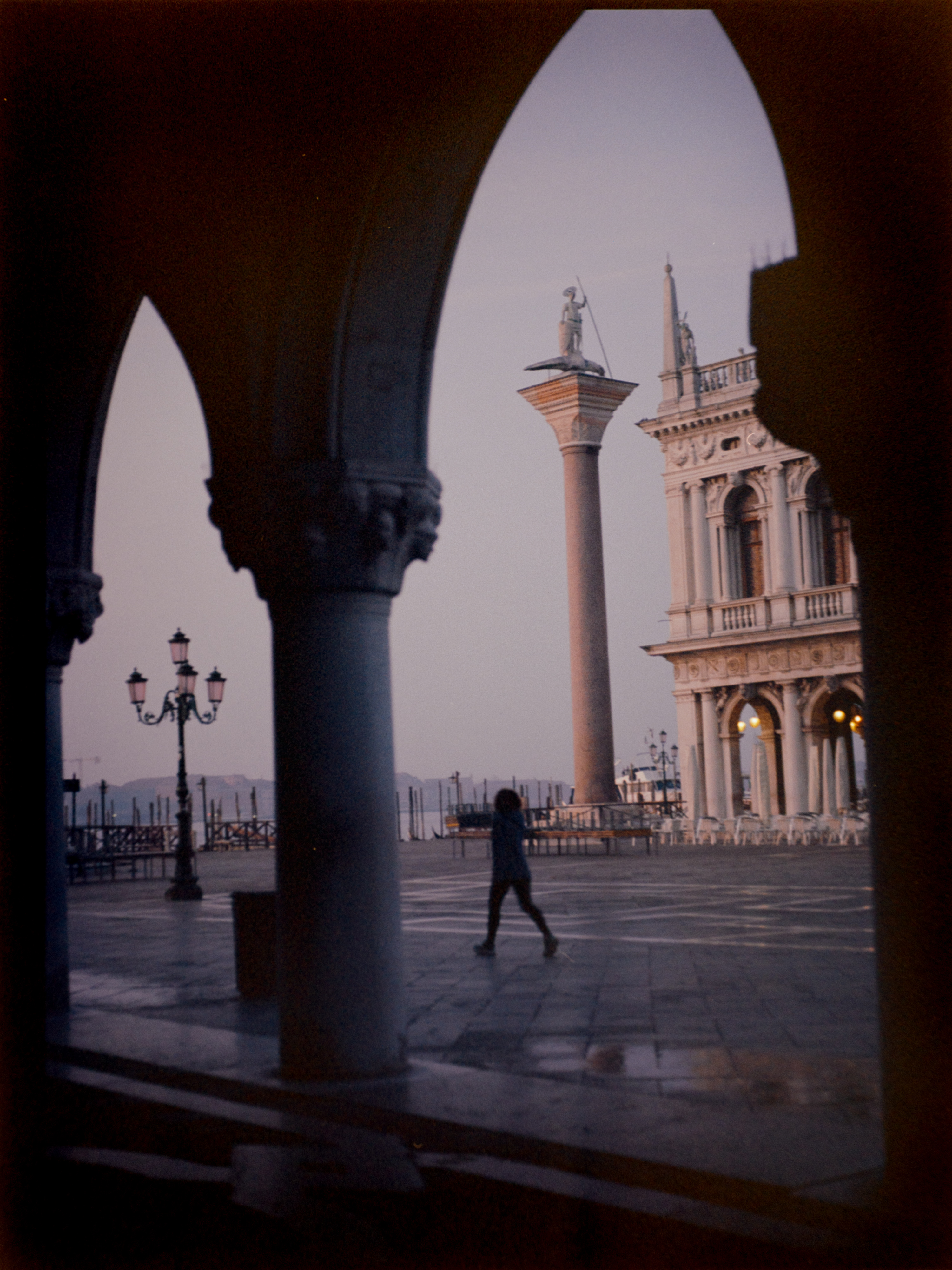 View from inside the Doge's Palace arcade at dusk looking through Gothic pointed arches — Venice on film