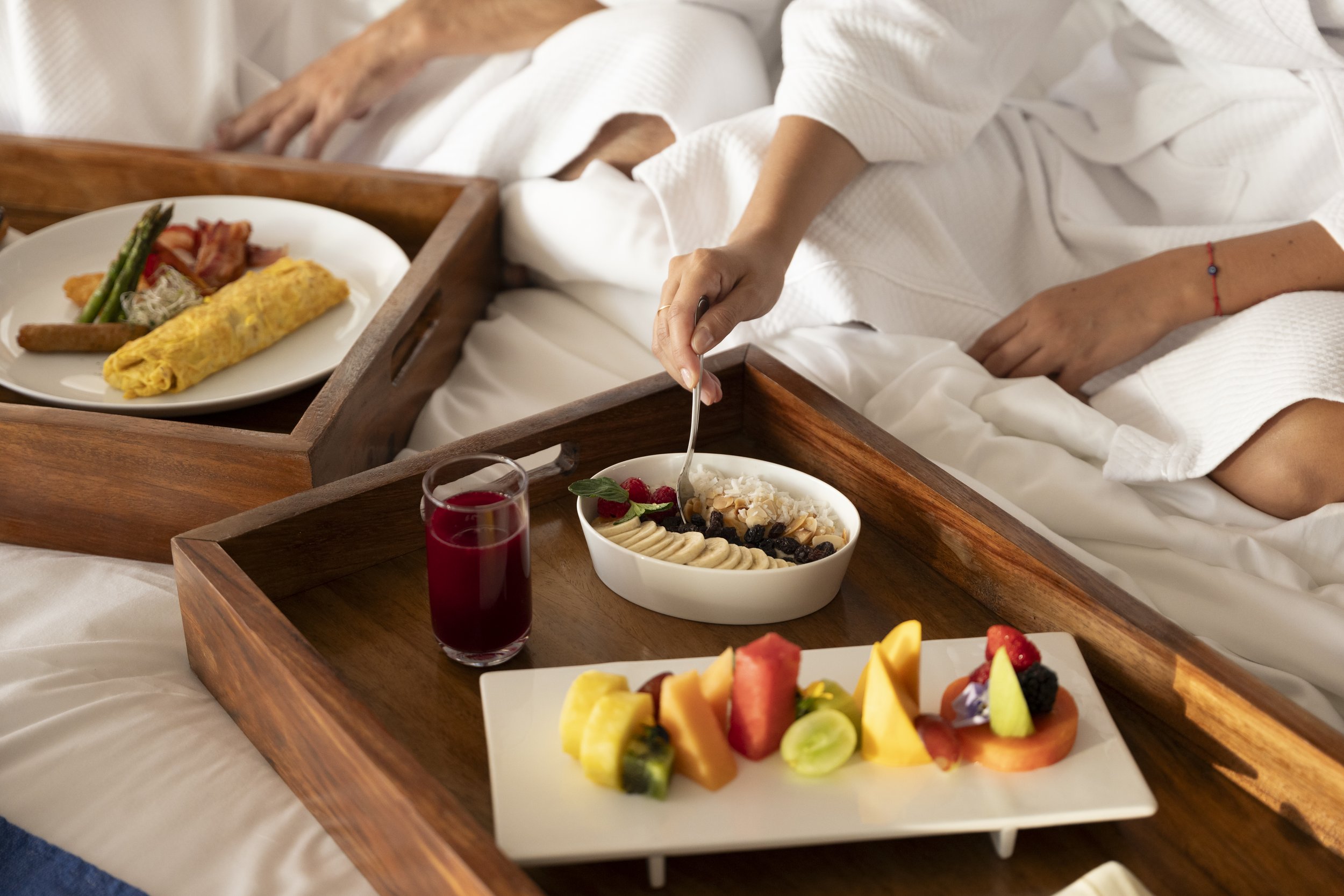 Couple in robes in-room breakfast bed room service