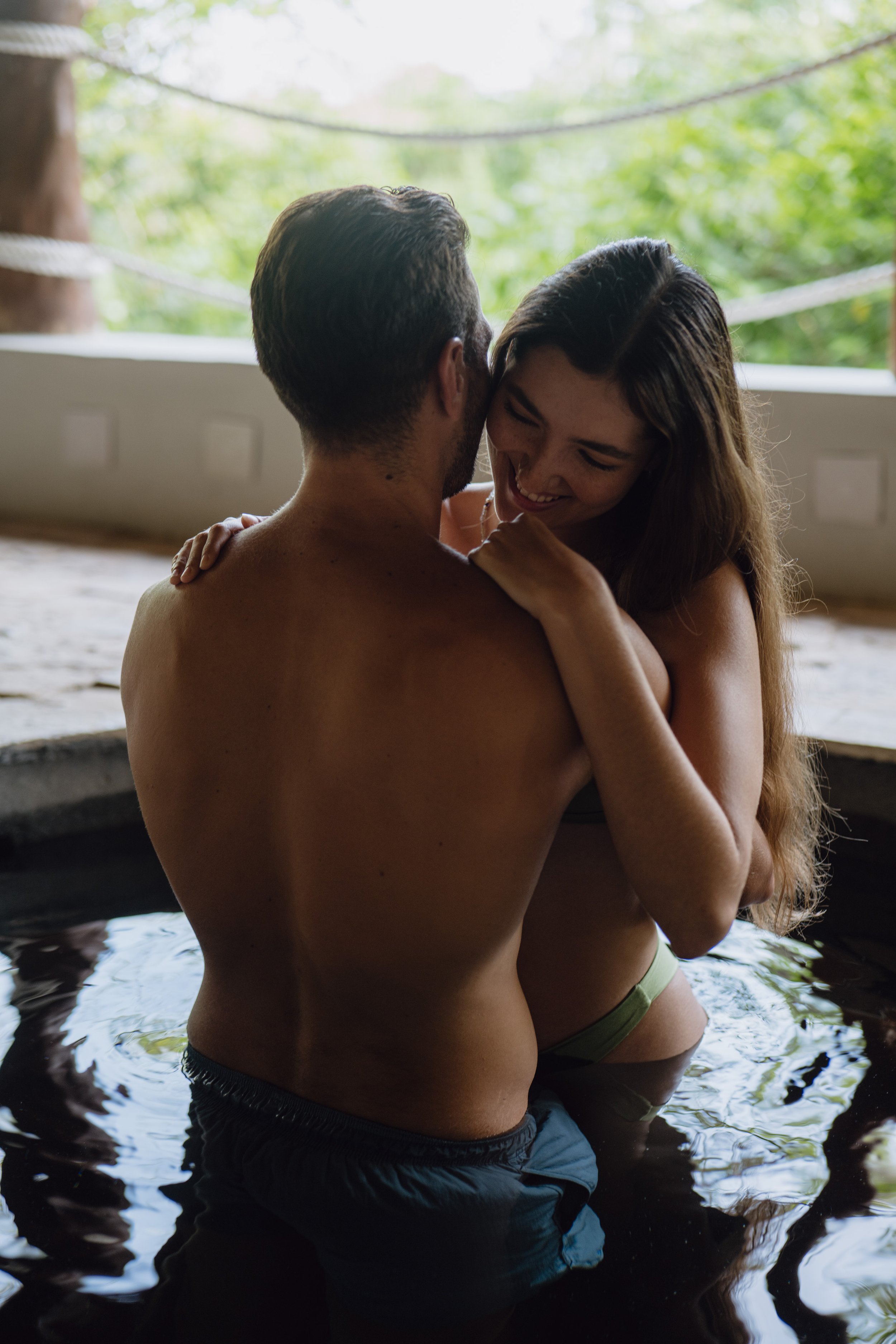 Couple in hot tub spa pool steam lush garden