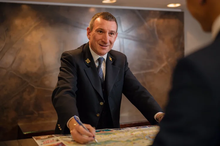 Hotel concierge at front desk assisting guests