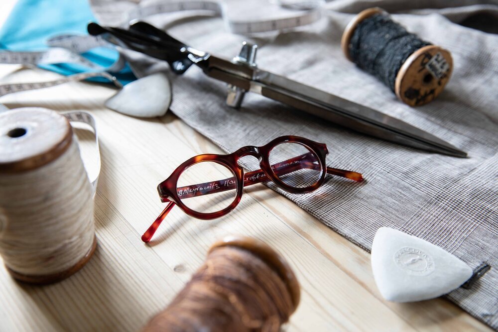 EB Meyrowitz luxury eyewear on tailor's table, product photography